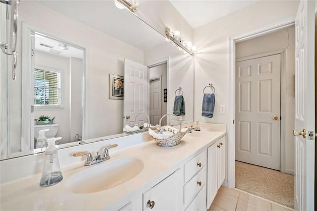 bathroom featuring toilet, vanity, and tile patterned flooring