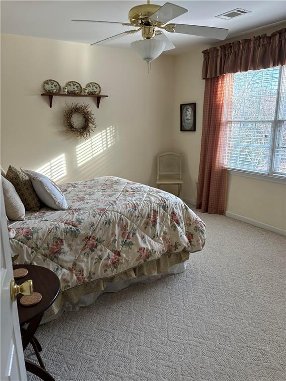 bedroom featuring ceiling fan and carpet