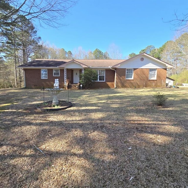 ranch-style house featuring a front yard and brick siding