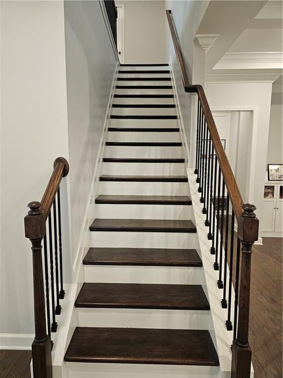 staircase featuring crown molding and hardwood / wood-style floors