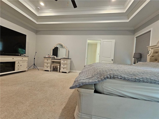 bedroom with ornamental molding, ceiling fan, a tray ceiling, and carpet