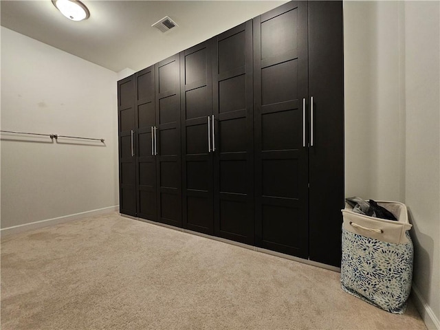 walk in closet featuring light carpet