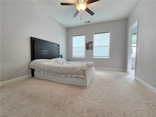 carpeted bedroom featuring vaulted ceiling, multiple windows, and ceiling fan