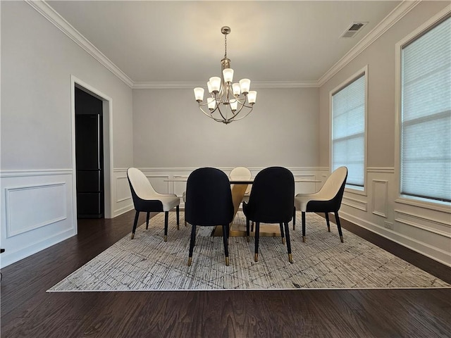 dining space featuring crown molding, an inviting chandelier, and wood-type flooring