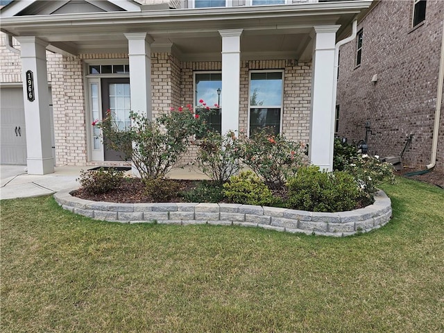 property entrance featuring a garage, a porch, and a yard