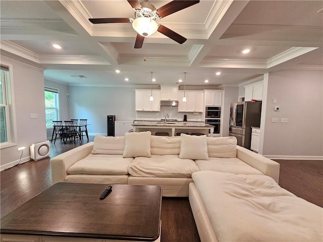 living room with beamed ceiling, sink, dark hardwood / wood-style flooring, crown molding, and coffered ceiling