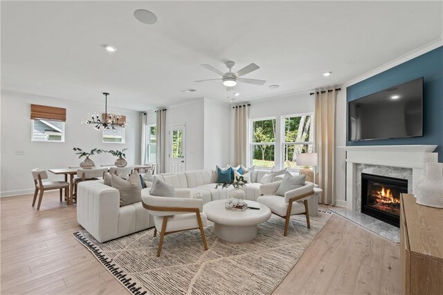 808 Tupelo Way, Villa Rica, GA 30180 - living room featuring light wood finished floors, baseboards, a fireplace, recessed lighting, and ceiling fan with notable chandelier