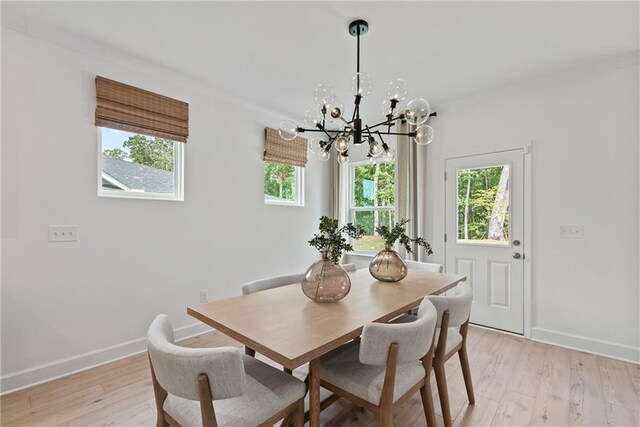 808 Tupelo Way, Villa Rica, GA 30180 - dining space featuring light wood-style flooring, a healthy amount of sunlight, and an inviting chandelier