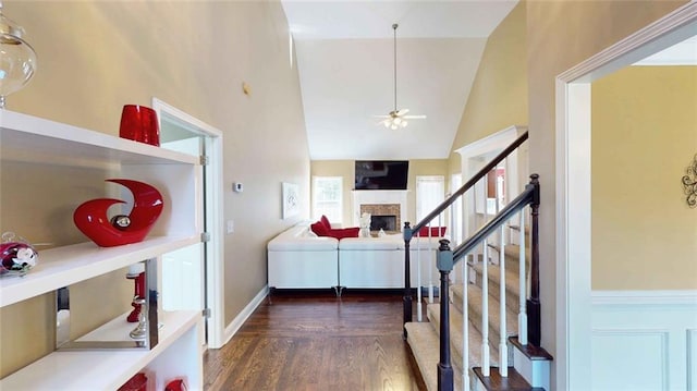 interior space featuring dark wood-type flooring, ceiling fan, and vaulted ceiling