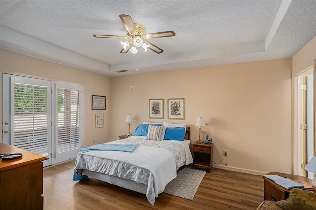 3264 Salem Cove Trl SE, Conyers, GA 30013 - bedroom with a tray ceiling, access to exterior, a textured ceiling, wood finished floors, and ceiling fan