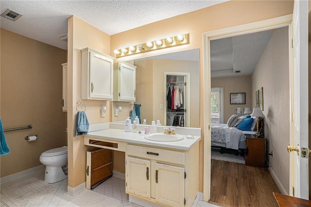 3264 Salem Cove Trl SE, Conyers, GA 30013 - ensuite bathroom with vanity, a textured ceiling, and a walk in closet