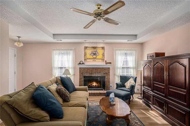 3264 Salem Cove Trl SE, Conyers, GA 30013 - living room featuring a textured ceiling, dark wood-style floors, ceiling fan, plenty of natural light, and a fireplace
