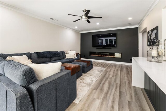 12380 Peyton Farm Way, Alpharetta, GA 30004 - living area with light wood finished floors, a ceiling fan, recessed lighting, ornamental molding, and a glass covered fireplace