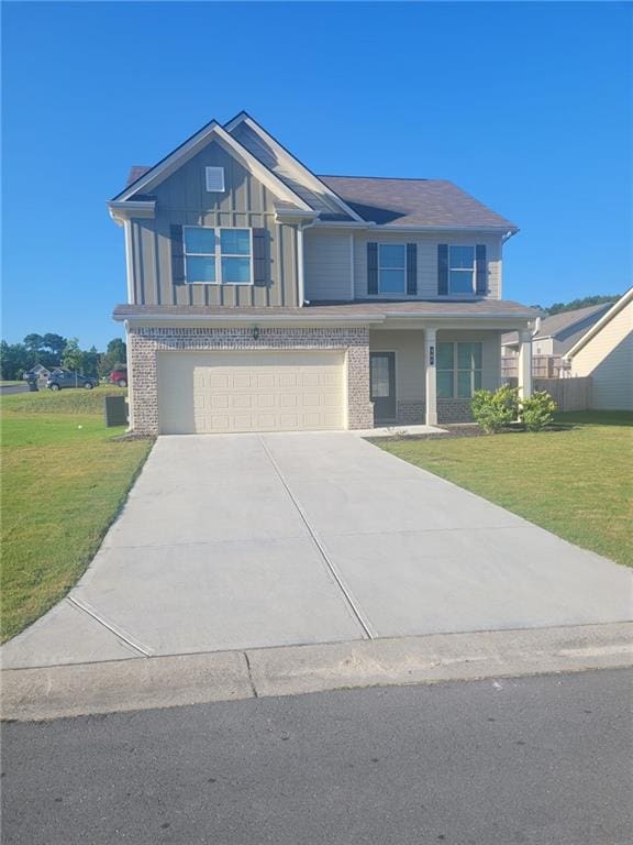 view of front of property featuring a garage, driveway, a front lawn, and board and batten siding