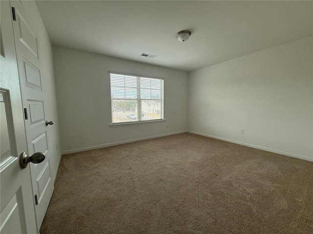 carpeted empty room featuring baseboards