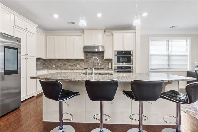 5910 Roxboro Ct, Cumming, GA 30040 - kitchen featuring dark wood-type flooring, visible vents, under cabinet range hood, and stainless steel appliances