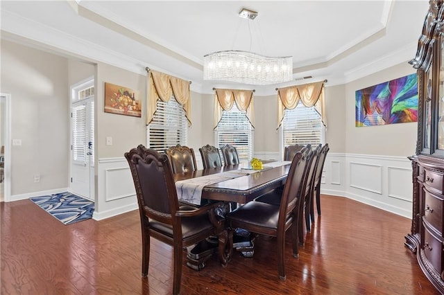5910 Roxboro Ct, Cumming, GA 30040 - dining room featuring a tray ceiling, dark wood-type flooring, crown molding, a decorative wall, and a notable chandelier