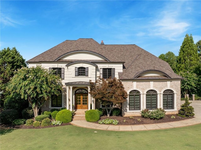 french country style house with a front lawn