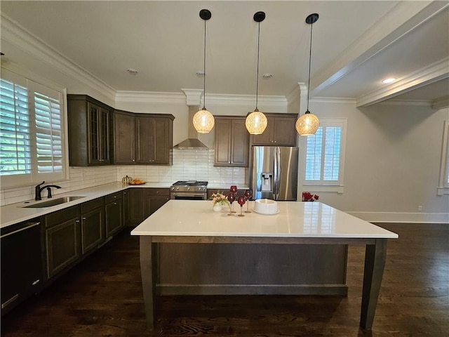 kitchen featuring appliances with stainless steel finishes, sink, dark brown cabinets, and a center island