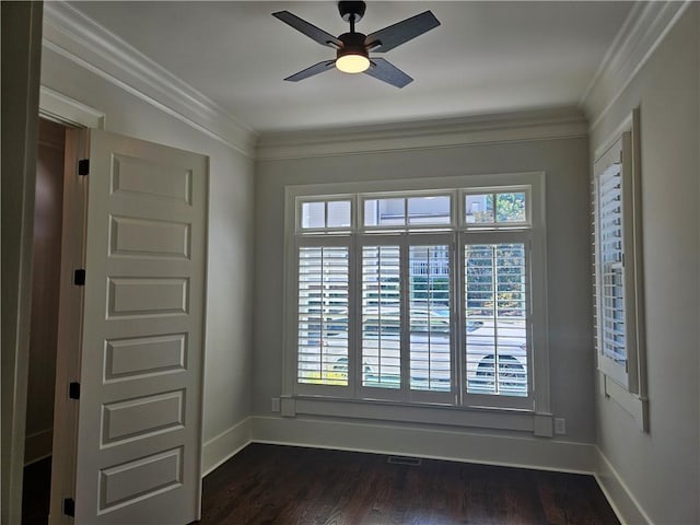 empty room with ceiling fan, dark hardwood / wood-style flooring, ornamental molding, and a healthy amount of sunlight