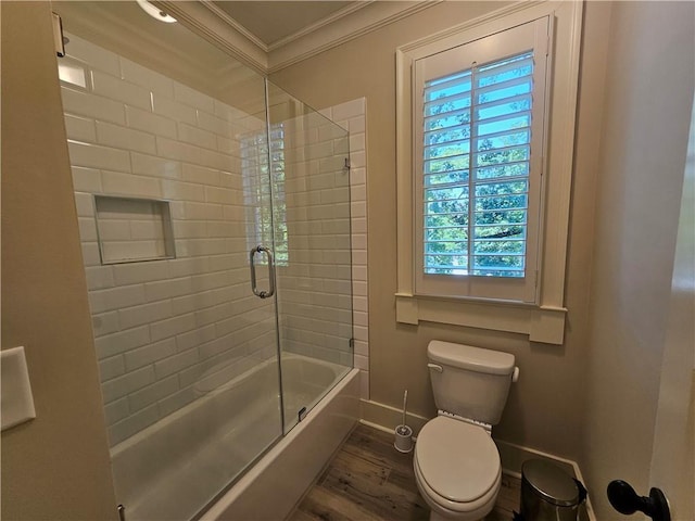 bathroom with combined bath / shower with glass door, toilet, crown molding, and hardwood / wood-style flooring