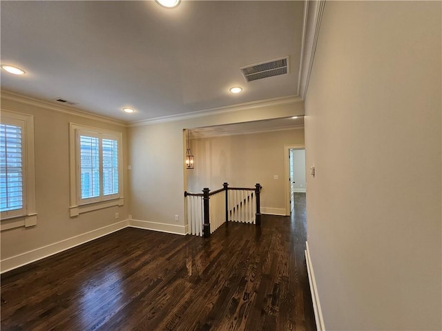 spare room featuring dark hardwood / wood-style floors and crown molding