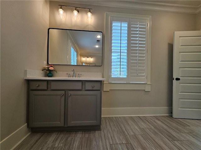 bathroom featuring a wealth of natural light, vanity, and ornamental molding