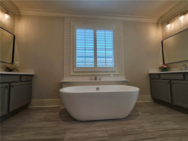 bathroom featuring a bathing tub, crown molding, and vanity