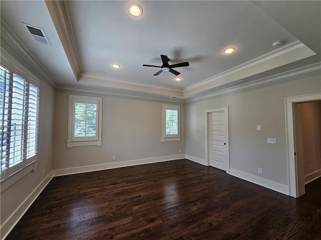 empty room with dark wood-type flooring, crown molding, a tray ceiling, and ceiling fan