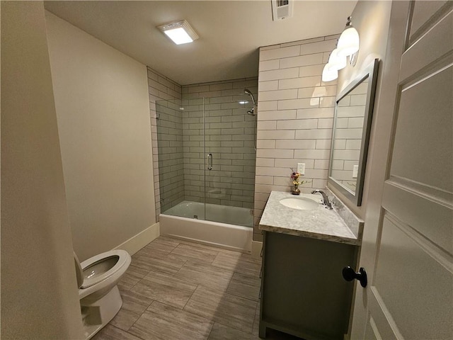 full bathroom with toilet, vanity, and shower / bath combination with glass door