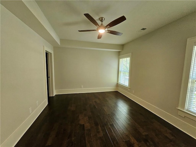 empty room with ceiling fan and dark hardwood / wood-style flooring