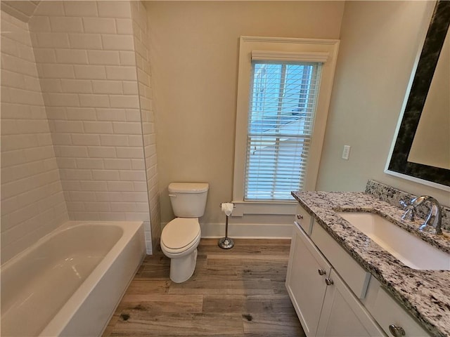 bathroom featuring toilet, vanity, wood-type flooring, and plenty of natural light