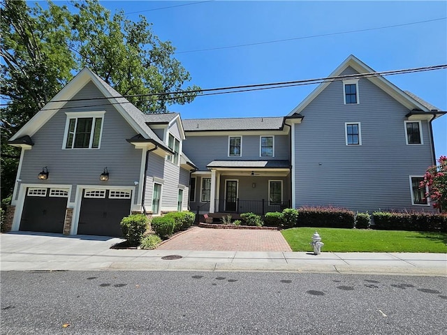 front of property with a front yard, covered porch, and a garage