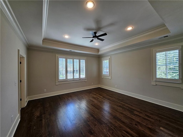 spare room featuring ceiling fan, dark hardwood / wood-style flooring, crown molding, and a tray ceiling