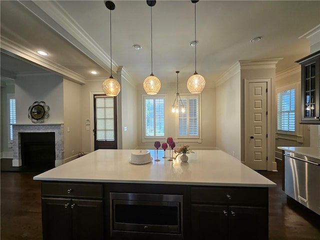 kitchen featuring stainless steel appliances, a kitchen island, dark hardwood / wood-style floors, decorative light fixtures, and ornamental molding