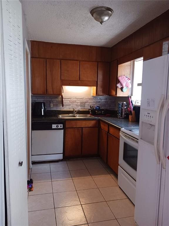 kitchen featuring decorative backsplash, sink, white appliances, and light tile patterned floors