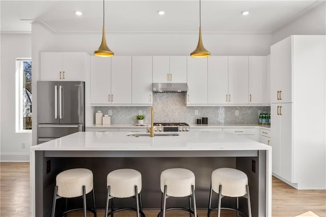 kitchen with pendant lighting, a kitchen island with sink, high end refrigerator, and white cabinets