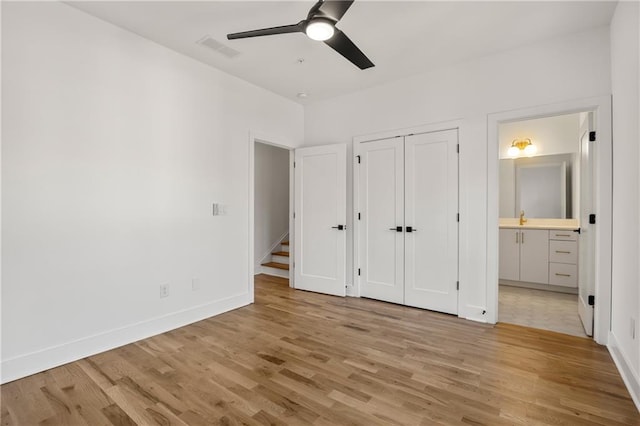 unfurnished bedroom with ceiling fan, ensuite bathroom, light hardwood / wood-style floors, and a closet