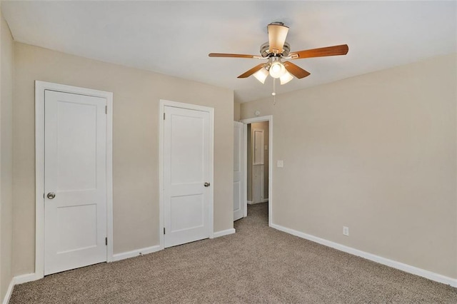 unfurnished bedroom with ceiling fan, two closets, and carpet