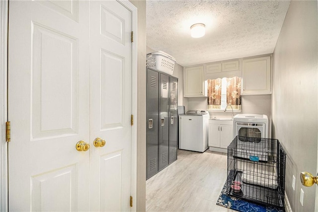 5396 Amhurst Dr, Peachtree Corners, GA 30092 - laundry area featuring cabinet space, a textured ceiling, washer and dryer, and light wood-type flooring
