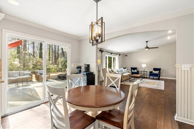 dining area with hardwood / wood-style flooring, ceiling fan, ornamental molding, and vaulted ceiling