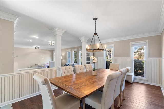 dining area with crown molding, plenty of natural light, dark hardwood / wood-style flooring, and decorative columns