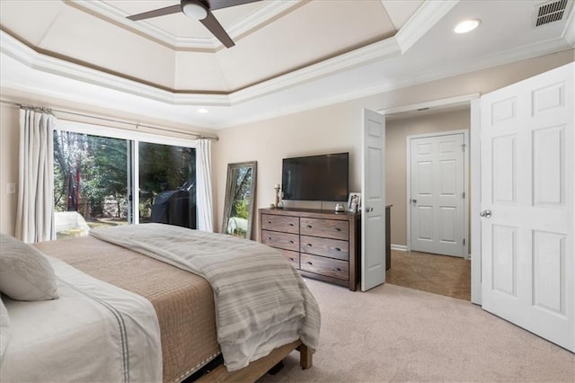 carpeted bedroom with crown molding, a tray ceiling, and ceiling fan