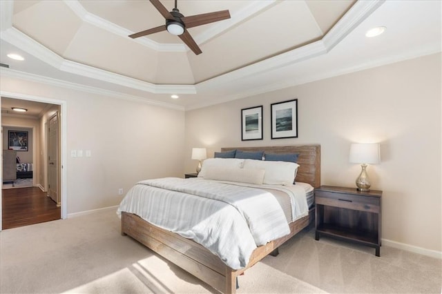 bedroom with a tray ceiling, ornamental molding, light colored carpet, and ceiling fan