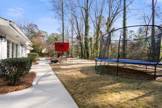 view of home's community with a trampoline and a lawn