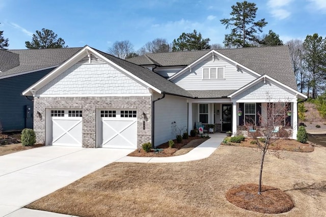 craftsman-style home featuring covered porch, concrete driveway, an attached garage, a shingled roof, and brick siding