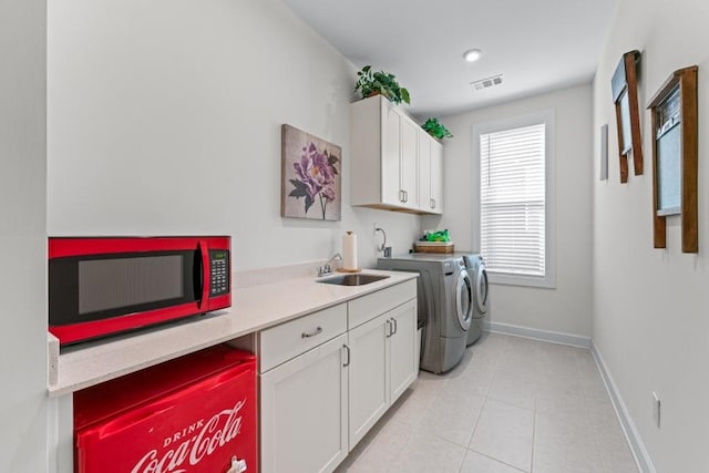 laundry room with baseboards, visible vents, cabinet space, a sink, and washer and clothes dryer