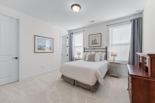 bedroom featuring light carpet, visible vents, and baseboards