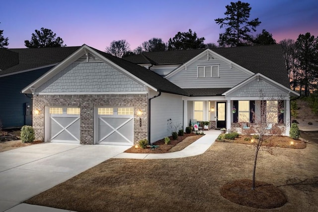 craftsman house featuring brick siding, an attached garage, and driveway