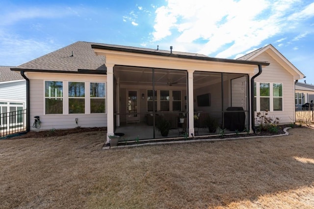 back of property with a shingled roof and a sunroom